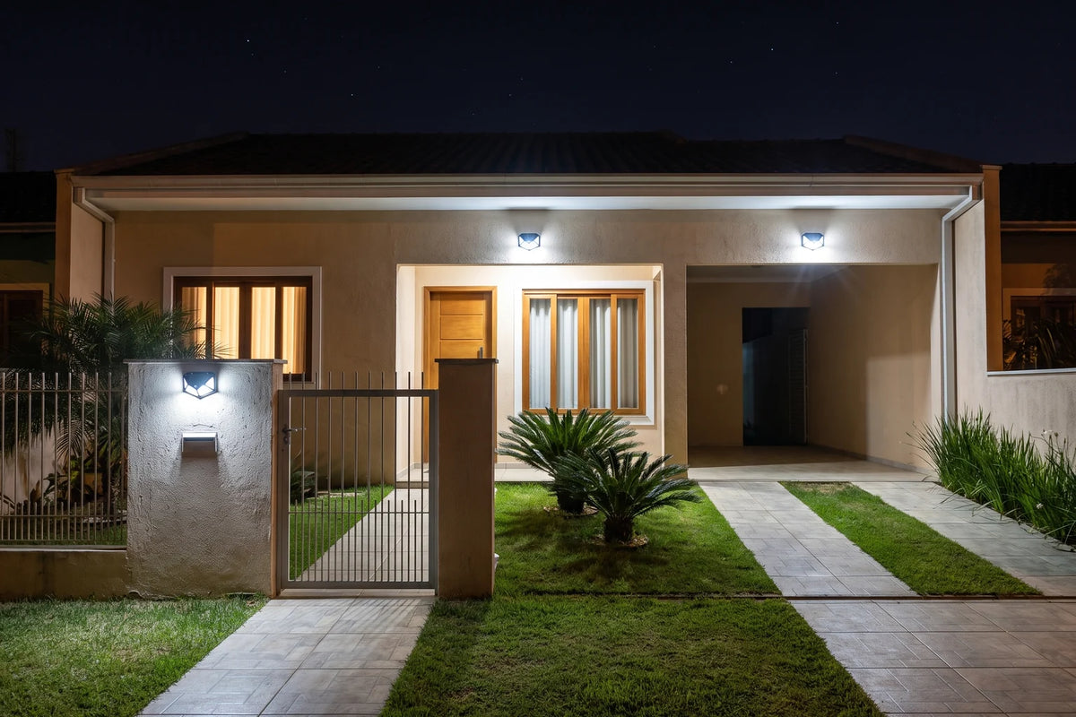 Fachada de casa à noite iluminada por luminárias solares com sensor